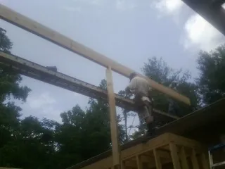 Carpenter setting a ridge beam over a new addition frame — Ice Dam Removal by Roofing Brothers in Cuba