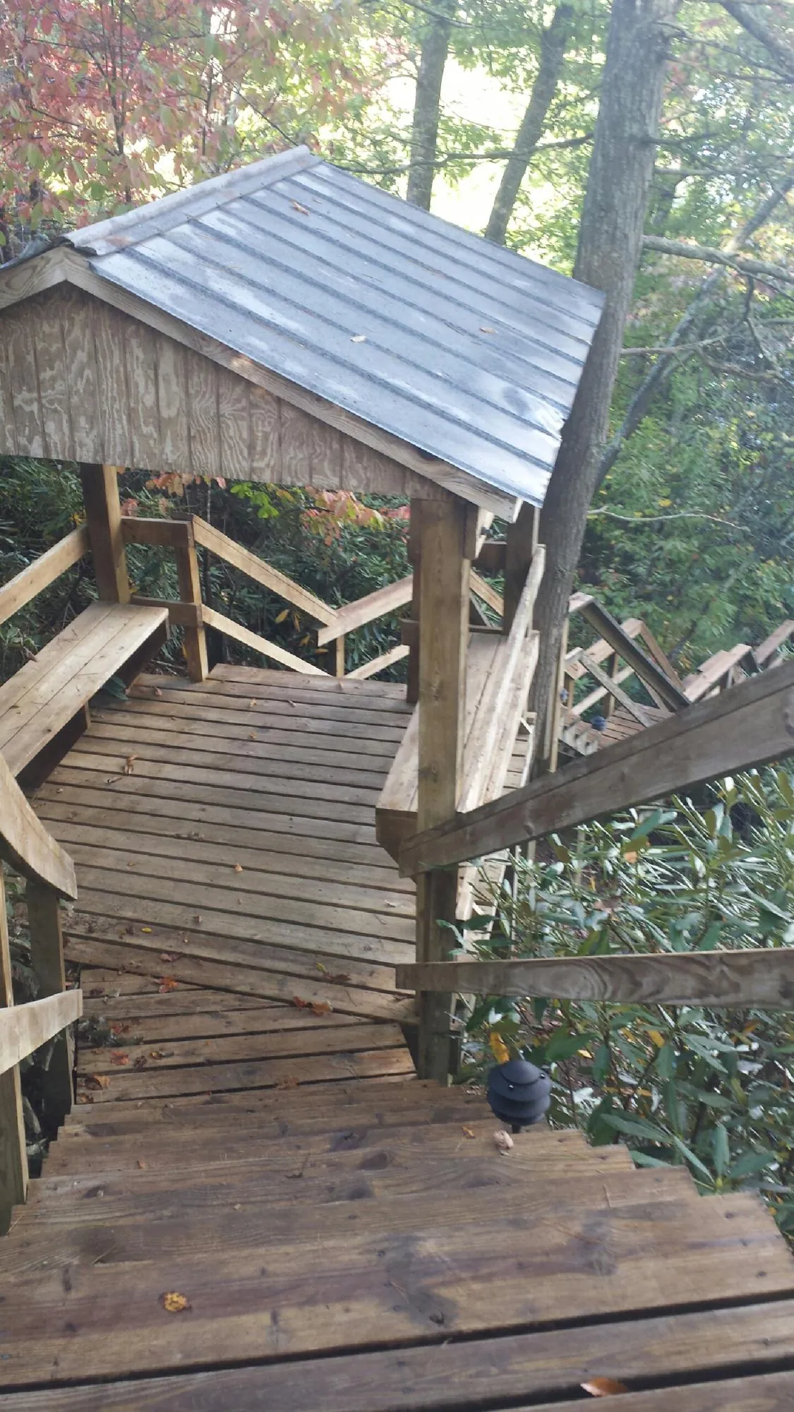 Metal roofed shelter over wooden steps on a wooded walkway — Skylight Repair & Installation work by our crew in Cuba